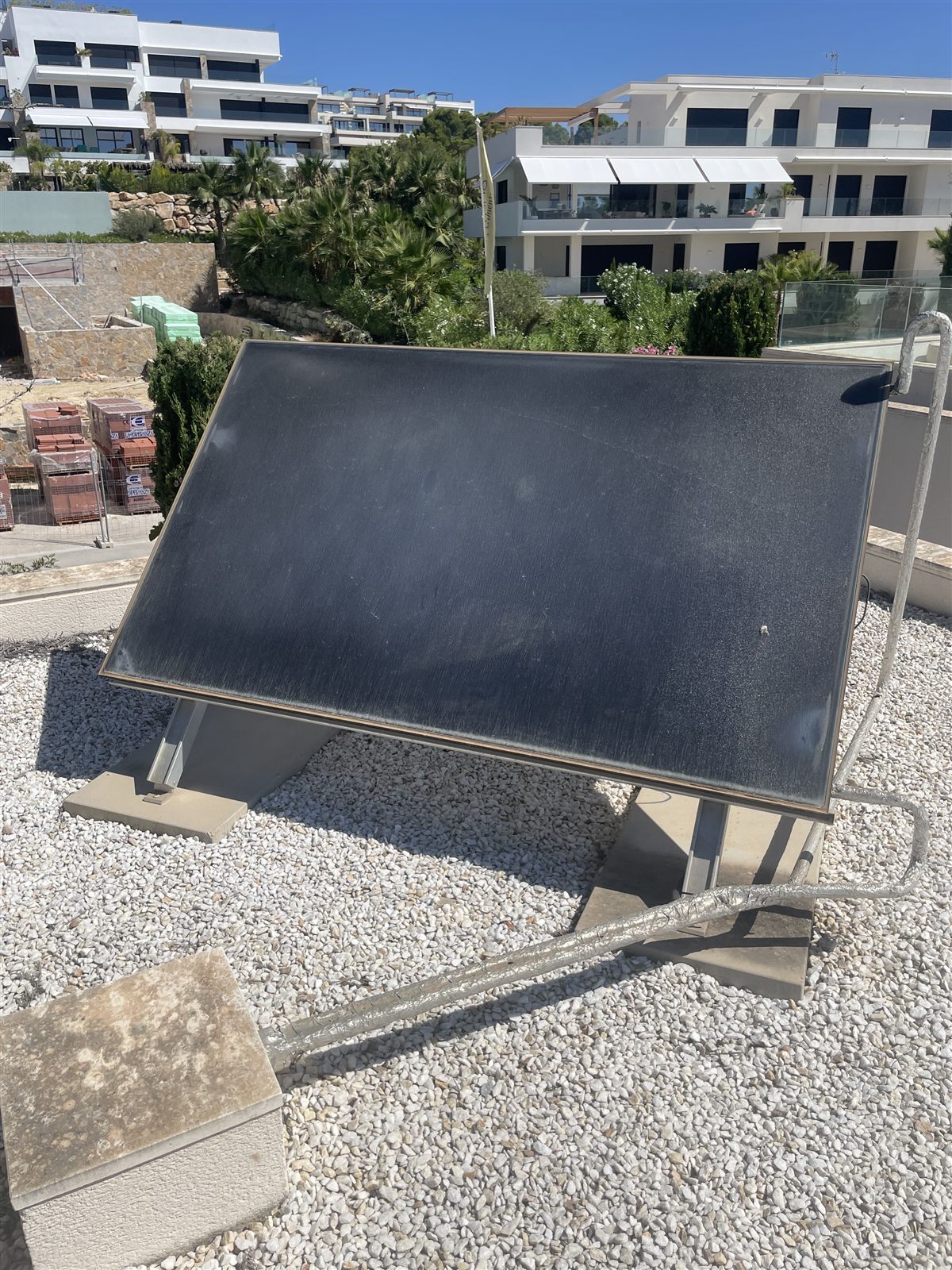 Placa solar sobre estructura inclinada en cubierta plana de grava en Torrevieja