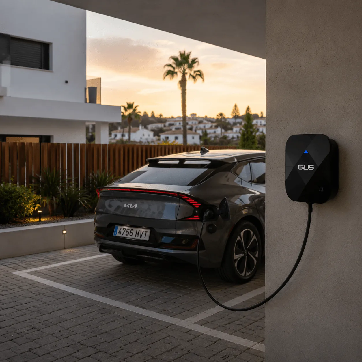 Wallbox KUBIC 74M instalado en la pared de un garaje cargando un coche eléctrico al atardecer